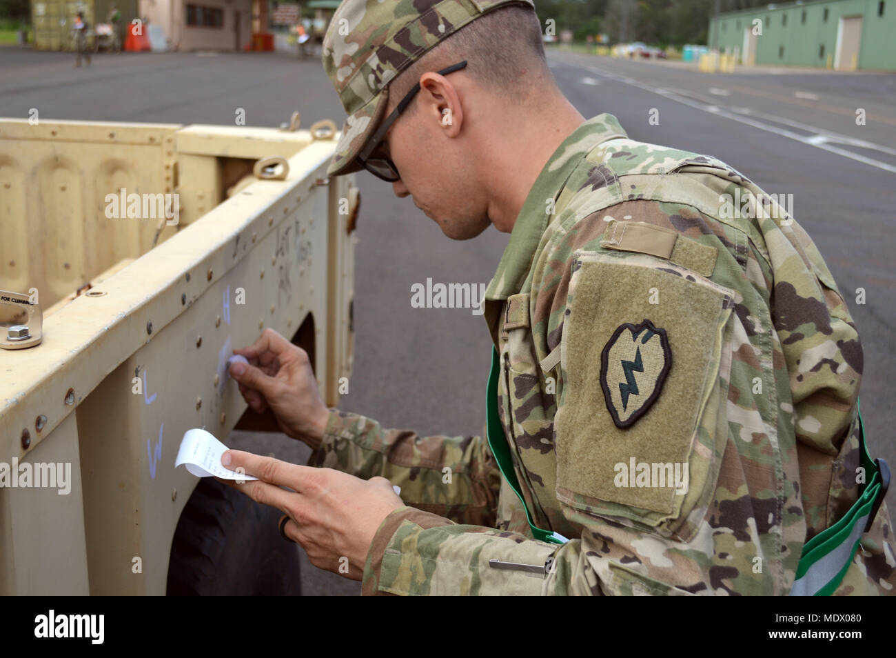 Un soldat affecté à la 25e Division d'infanterie, écrit une bandes-annonces dimensions physiques et le poids sur le côté au déploiement de plusieurs installations à Wheeler Army Airfield, New York, le 13 décembre, 2017. Les véhicules de la 25e ID sont prêts pour leur transit à Pearl Harbor et ensuite expédiés au Texas pour être utilisé à l'Joint Readiness Training Center à Fort Polk, en Louisiane, l'année prochaine. (U.S. Photo de l'armée par le sergent. Armando R. Limon, 3e Brigade Combat Team, 25e Division d'infanterie) Banque D'Images