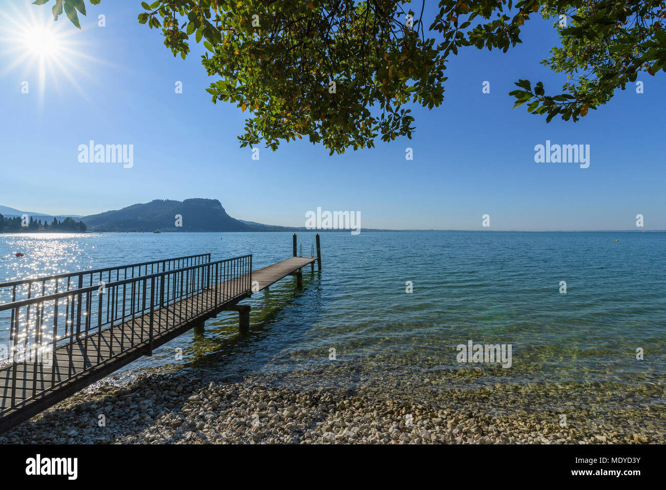 Soleil sur le lac de Garde (Lago di Gardo) avec sol en bois jetée dans l'été à Garda en Vénétie, Italie Banque D'Images