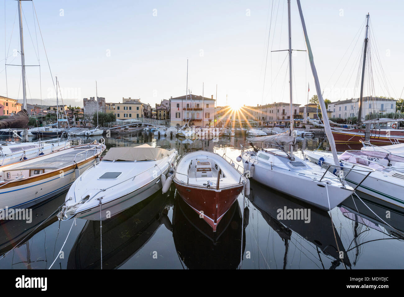 Rangée de bateaux dans le port de plaisance au lever du soleil sur le lac de Garde (Lago di Garda) à Bardolino en Vénétie, Italie Banque D'Images
