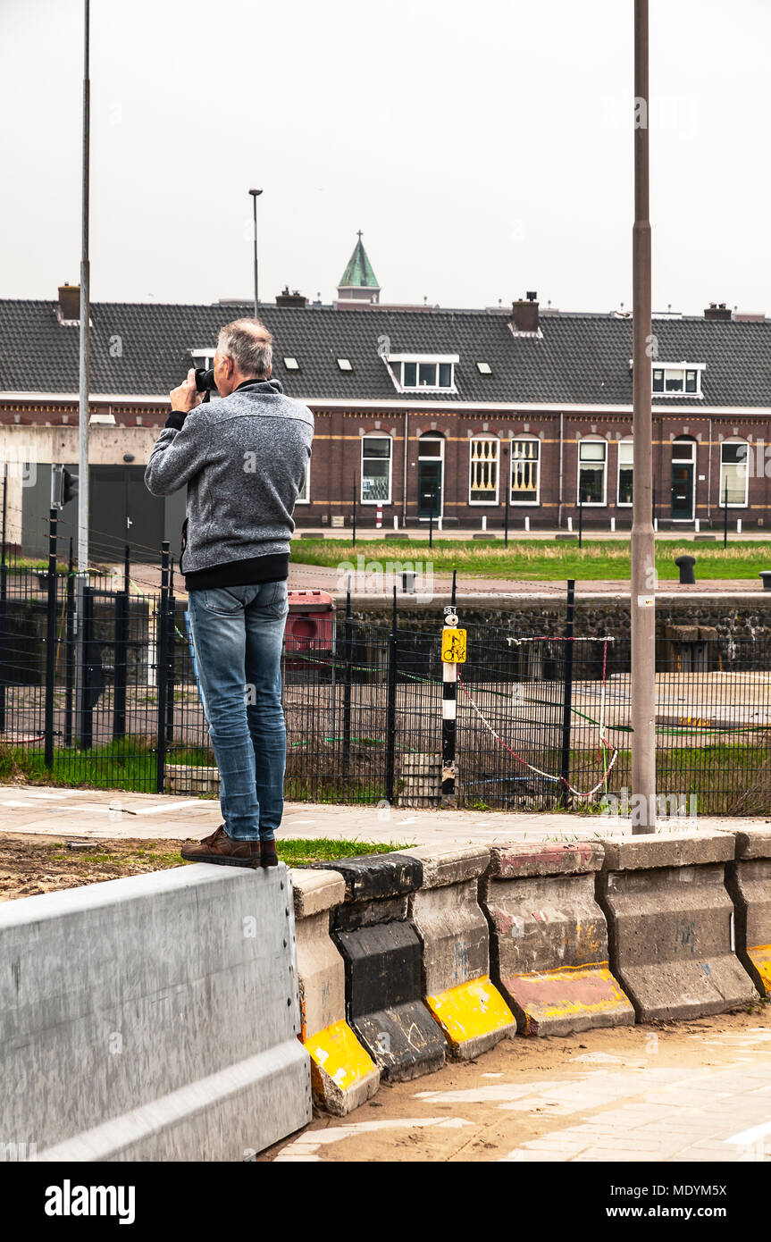 L'homme se tient sur un bloc de béton à la prise de photos Banque D'Images