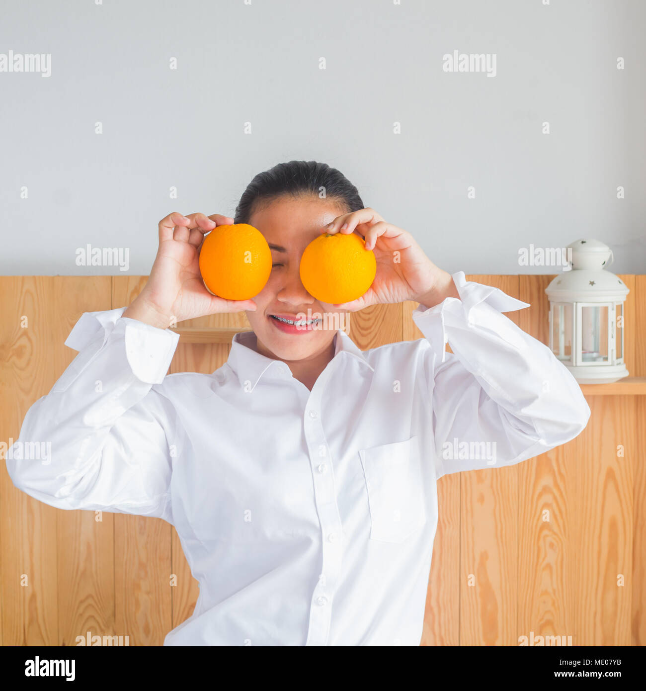 Close up face of Young Asian woman smiling and holding orange dans la main. Banque D'Images