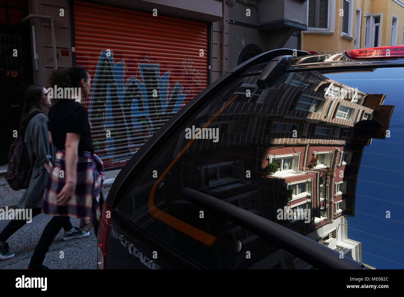 Istanbul, Turquie - le 19 avril 2018 Parfait : réflexions de la maisons turques sur une fenêtre du véhicule et également moderne jeune peuple turc sont la marche à Banque D'Images