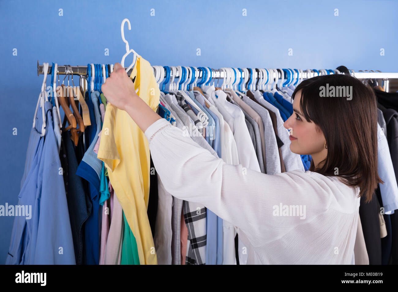 Close-up of a Young Woman Choosing Vêtements sur tringle Banque D'Images