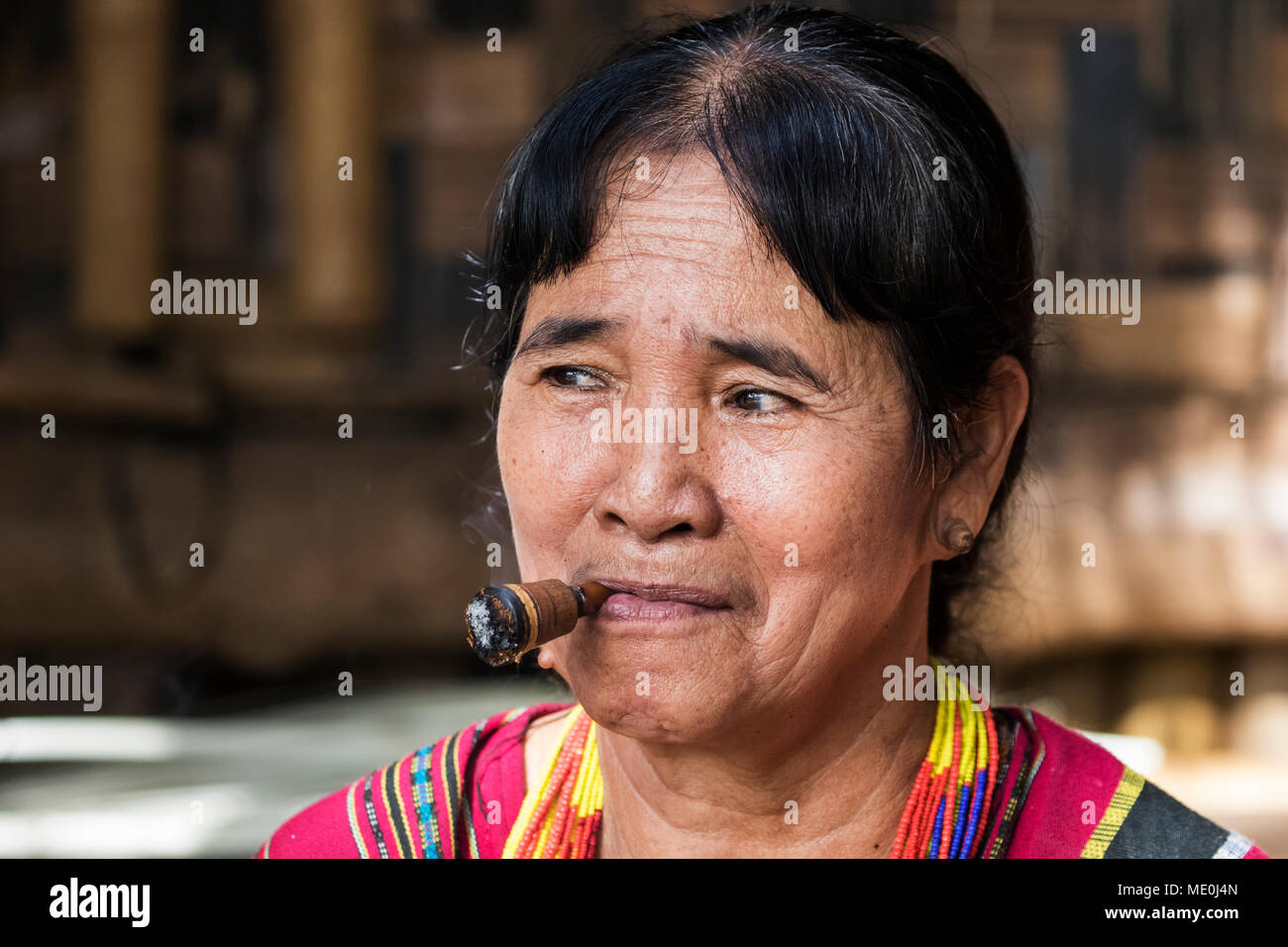 Lavae femme fumant un cigare dans le village ethnique à Pha Suam, Plateau des Bolavens, Champassak, Laos Banque D'Images