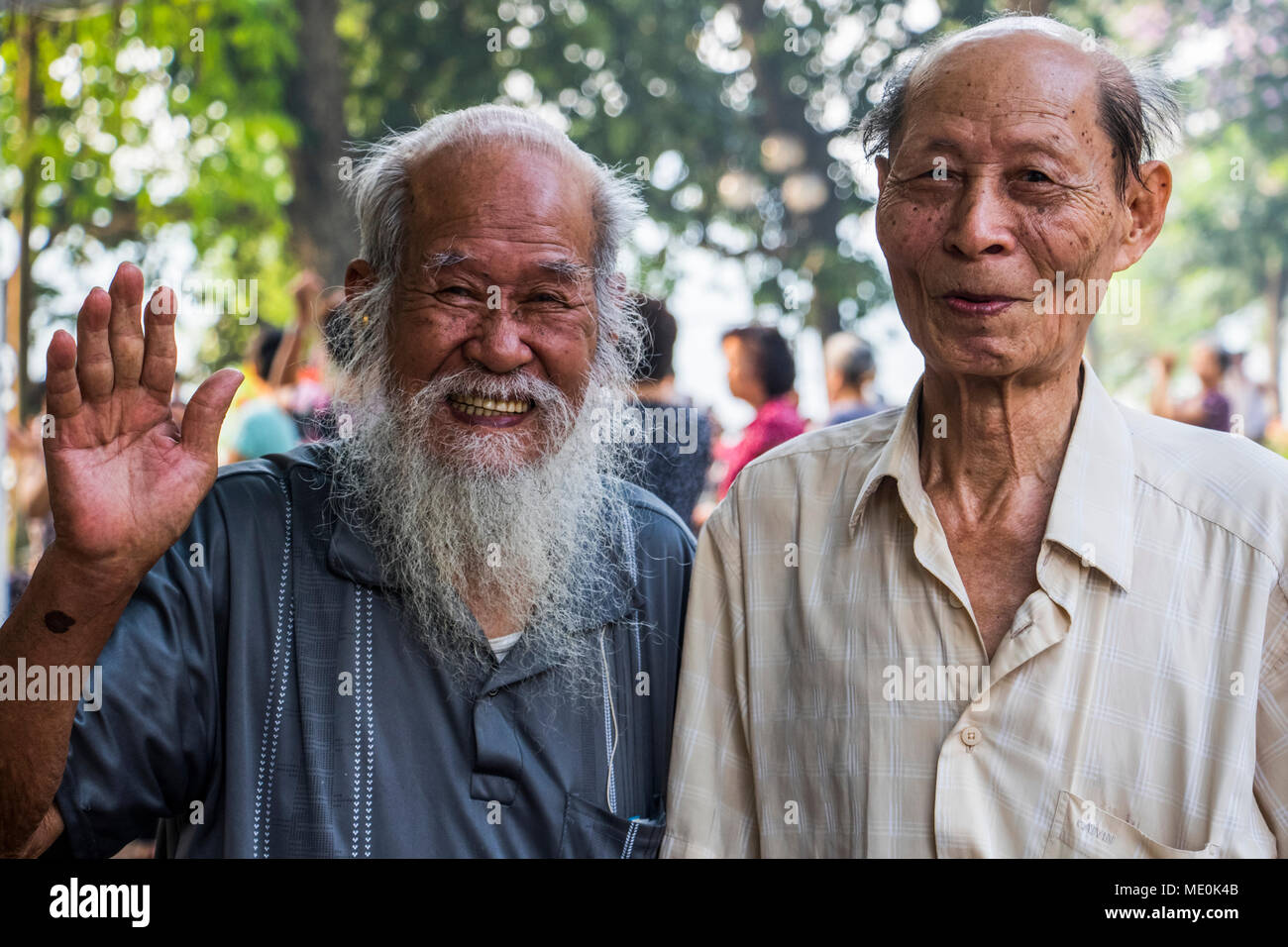 Poser des hommes âgés en souriant et en agitant pour l'appareil photo ; Hanoi, Hanoi, Vietnam Banque D'Images