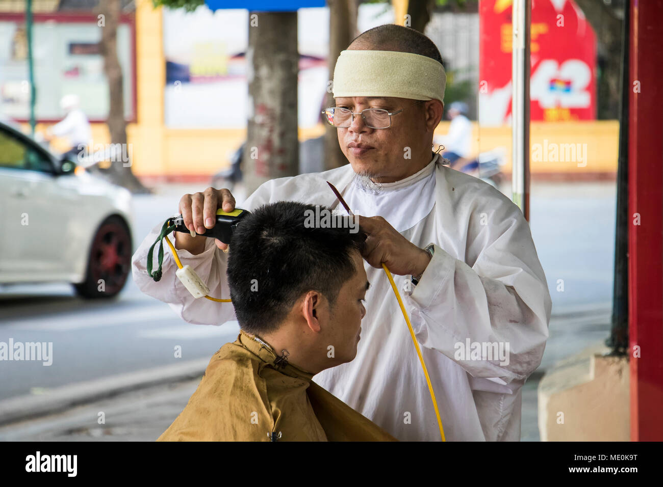 Salon de coiffure de la rue en donnant une coupe dans le vieux quartier, Hanoi, Hanoi, Vietnam Banque D'Images