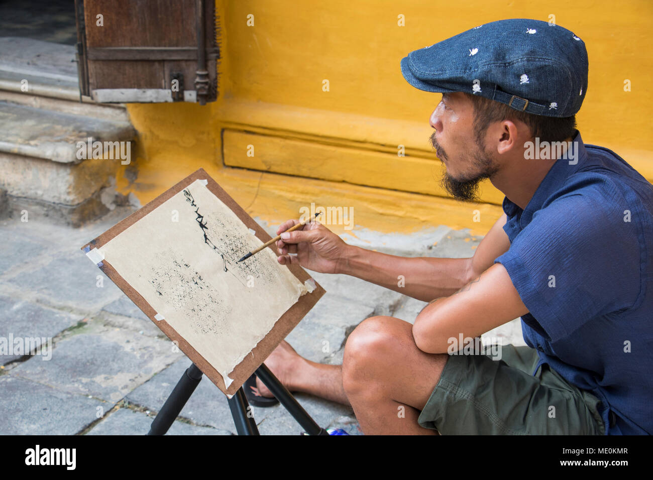 Man painting sur rue dans le vieux quartier, Hoi An, Quang Nam, Vietnam Banque D'Images