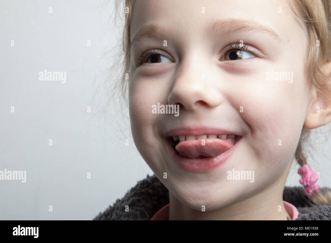 Happy little girl montrant sa langue. Banque D'Images