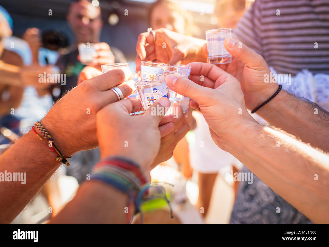 Photo Gros plan d'un des hommes les mains avec verre de boisson alcoolisée, parlant de toasts, Cheers, célèbre maison de vacances plein air, vacances d'été, heureux parti Banque D'Images