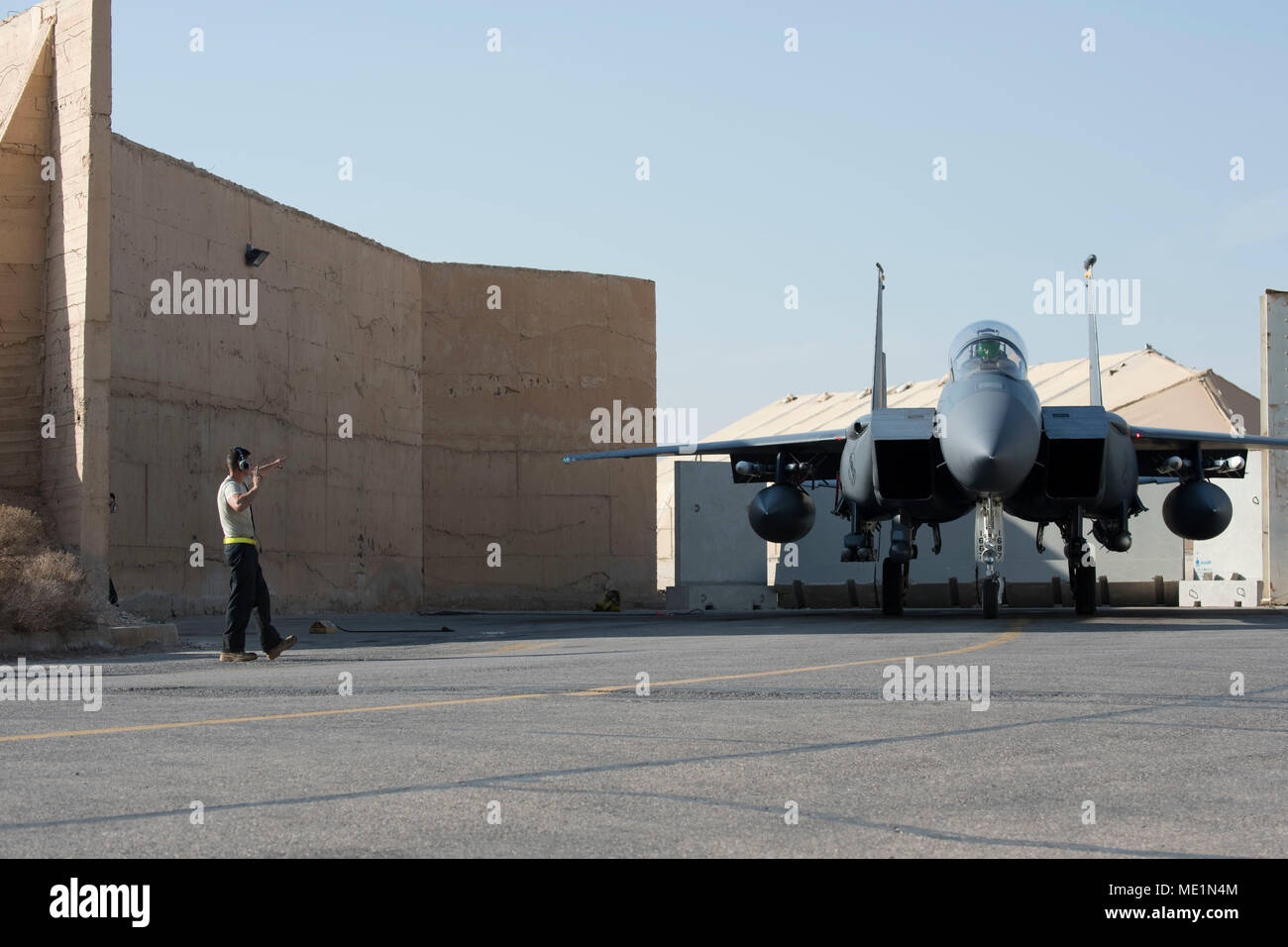 332e Escadron de maintenance un corps expéditionnaire chef d'équipe dirige un F-15E Strike Eagle hors de son hanger avant le décollage le 7 mars 2018, dans un endroit inconnu en Asie du sud-est. Le F-15E est capable de voler Mach 2,5 et peut transporter la plupart des armes de l'Armée de l'air de l'inventaire. (U.S. Photo de l'Armée de l'air par la Haute Airman Krystal Wright) Banque D'Images