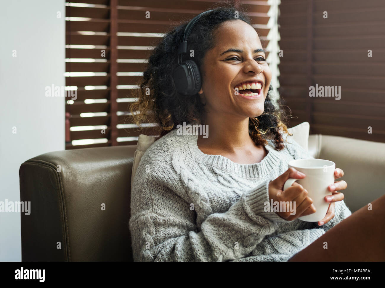 Woman enjoying music sur son canapé Banque D'Images