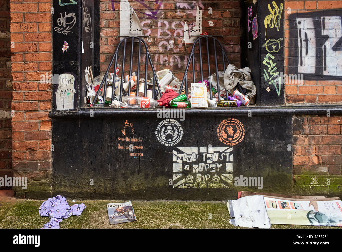 Ordures rue entassés dans une ruelle dans le centre de Manchester Banque D'Images