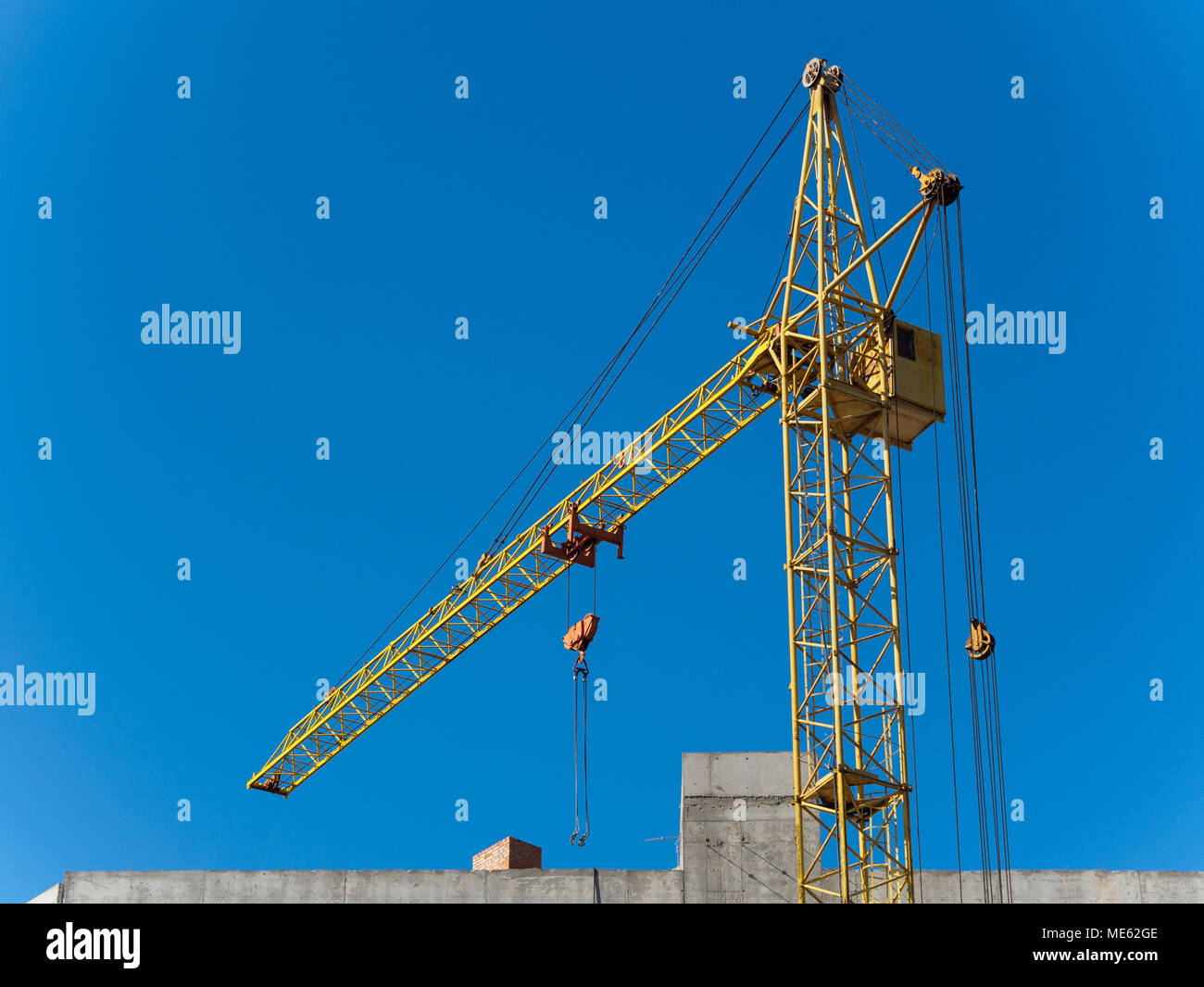 Grue jaune de travail avec le ciel bleu sur l'arrière-plan Banque D'Images