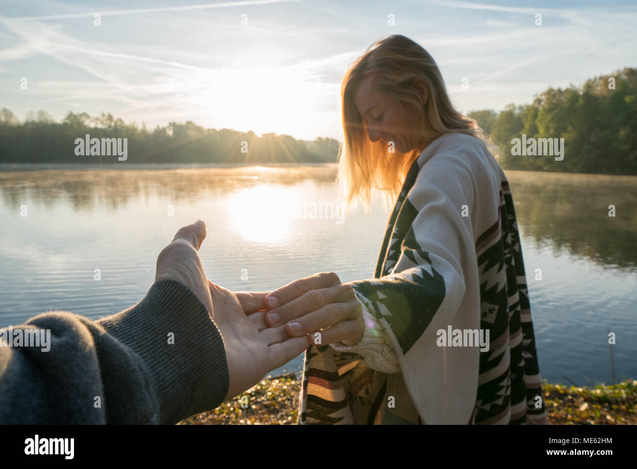 Suivez-moi de concept, jeune femme menant à la rive du petit ami au lever du soleil, tenant les mains, les gens voyagent couple début. Tourné en France, en Europe Banque D'Images
