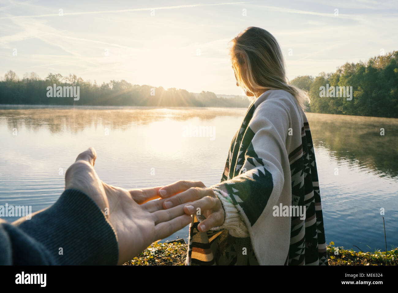 Suivez-moi de concept, jeune femme menant à la rive du petit ami au lever du soleil, tenant les mains, les gens voyagent couple début. Tourné en France, en Europe Banque D'Images