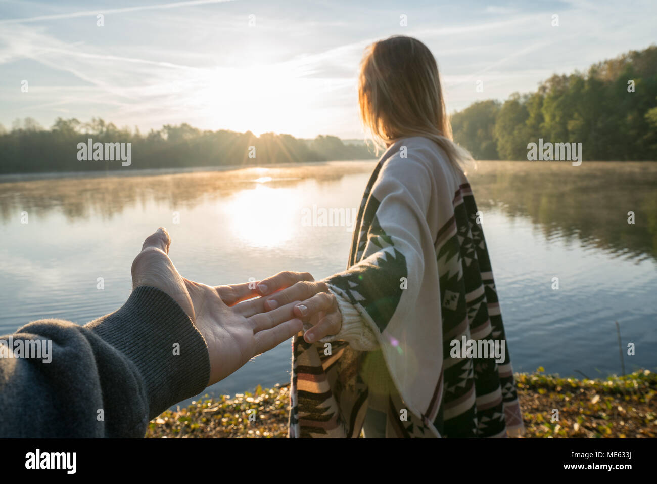 Suivez-moi de concept, jeune femme menant à la rive du petit ami au lever du soleil, tenant les mains, les gens voyagent couple début. Tourné en France, en Europe Banque D'Images