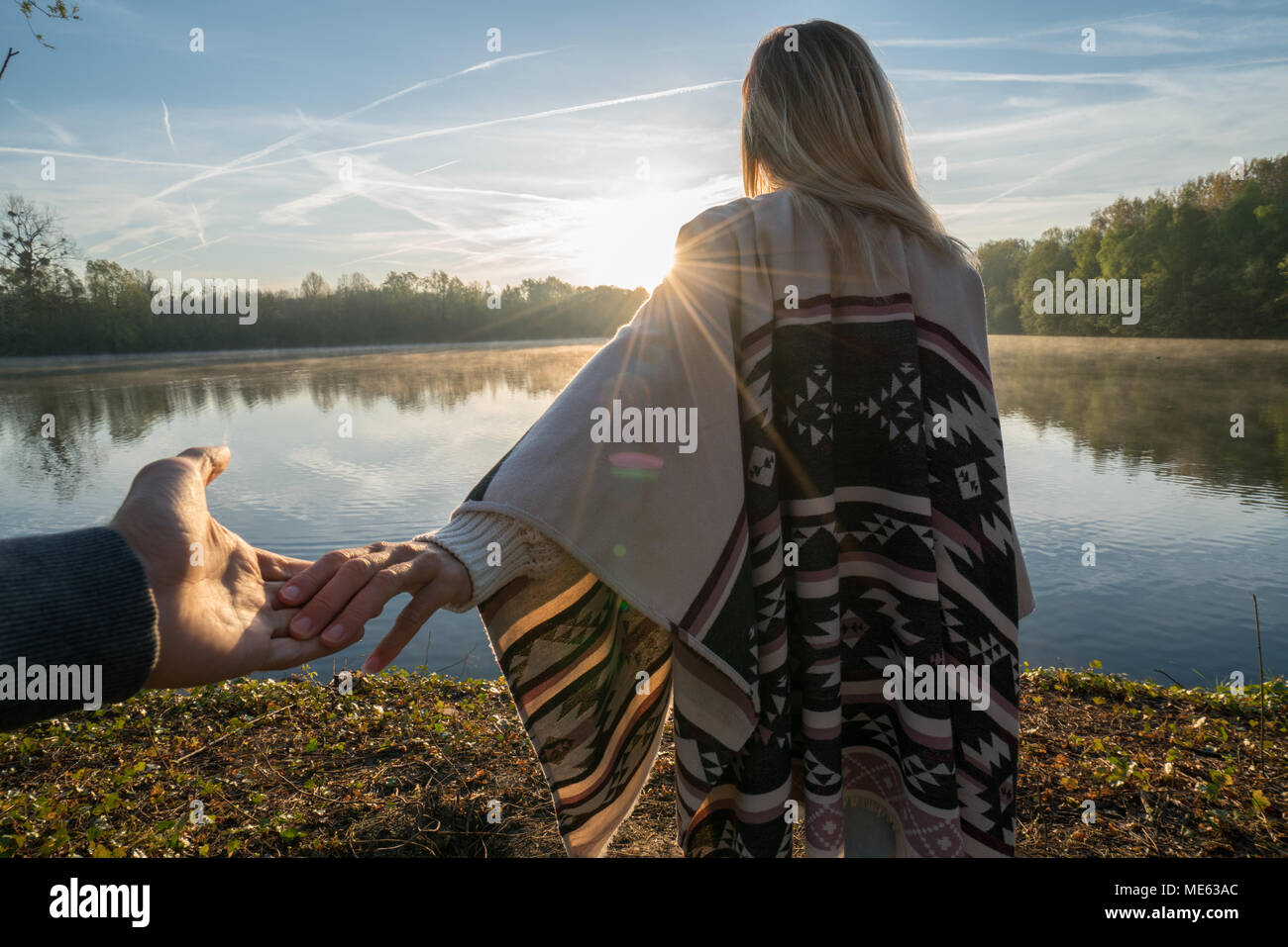 Suivez-moi de concept, jeune femme menant à la rive du petit ami au lever du soleil, tenant les mains, les gens voyagent couple début. Tourné en France, en Europe Banque D'Images