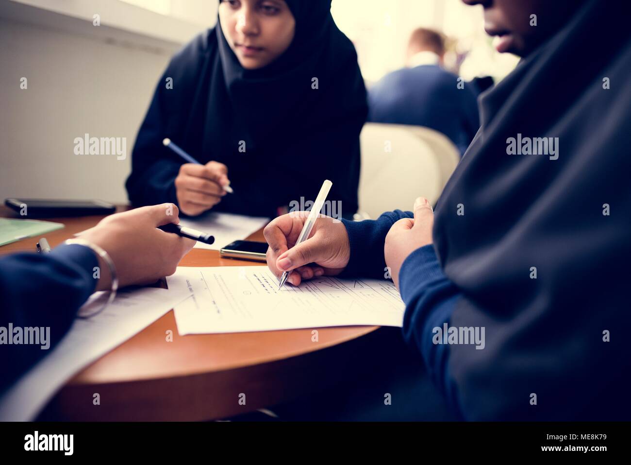 Les filles musulmanes diverses études dans une salle de classe Banque D'Images