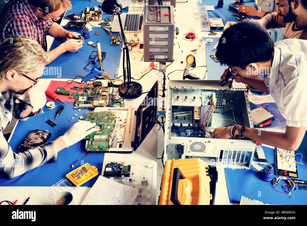 Techniciens en électronique équipe travaillant sur les pièces d'ordinateurs Banque D'Images