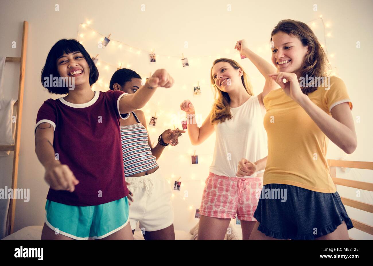 Groupe de diverses femmes s'amusant sur le même lit Banque D'Images