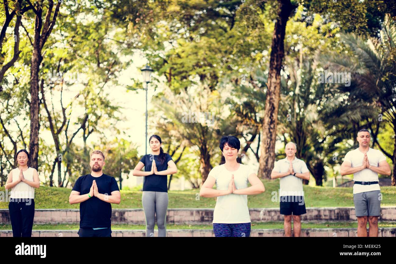 Les personnes faisant du yoga au parc Banque D'Images