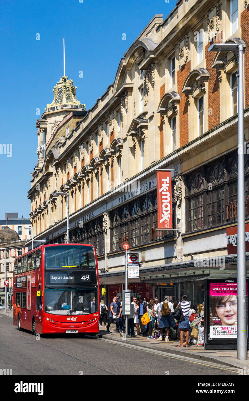 Un rouge à 49 London bus un arrêt de bus devant l'ancien Arding et Hobbs department store building à Clapham Junction dans le sud de Londres. Banque D'Images