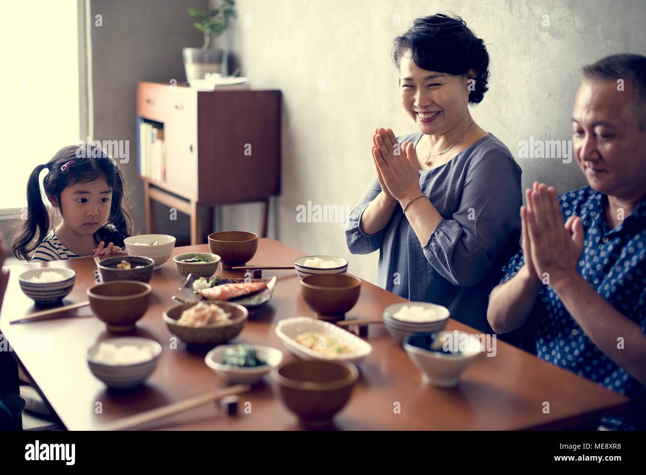 Famille japonaise priant ensemble Banque D'Images