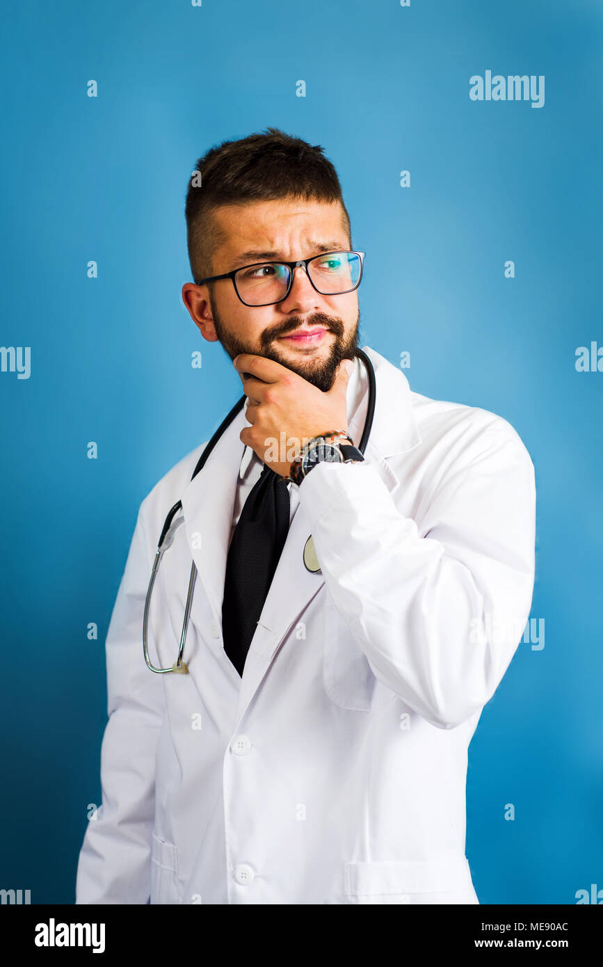 Portrait d'un jeune médecin contre fond bleu Banque D'Images