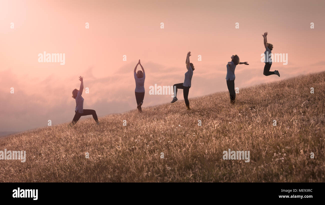 Groupe de même heureux happy girls training yoga exercice sur terrain idyllique à belle journée ensoleillée au-dessus des nuages Banque D'Images