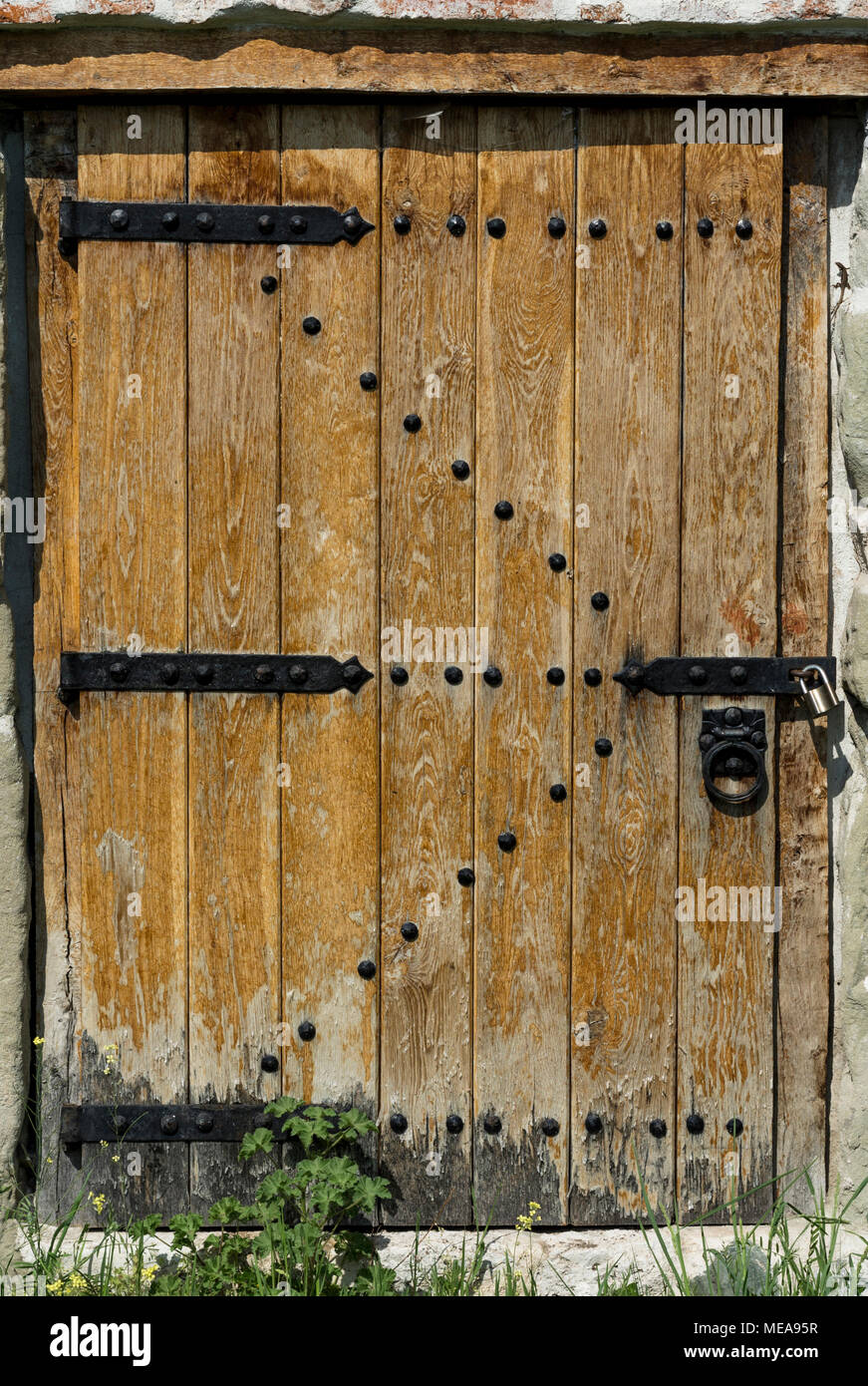 Vieille porte en bois en mur de pierre avec un cadenas. Fond texturé architecte Banque D'Images