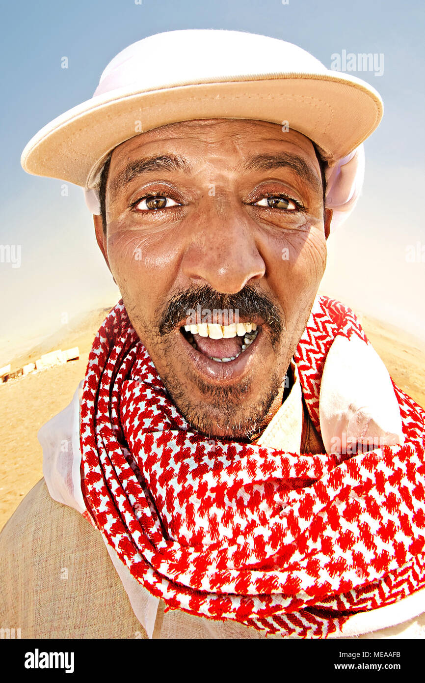 Souriant dans un bédouin capuchon blanc et foulard rouge Banque D'Images