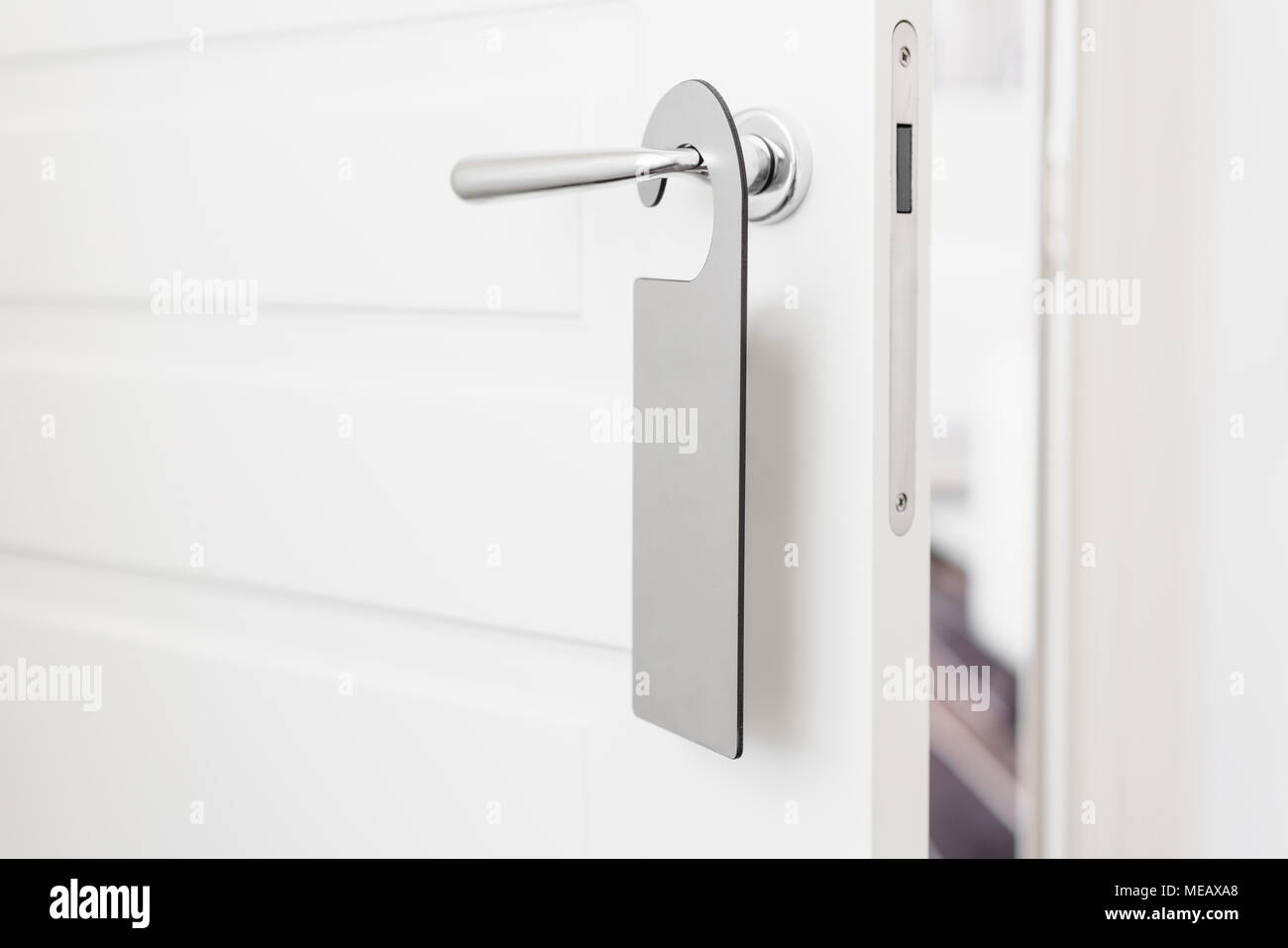 Bouton de porte avec étiquette vide sur une poignée de porte pour votre  texte. Maquette flyer blanche vide accrocher sur la poignée de la porte.  Notice sur la poignée d'entrée de conception.