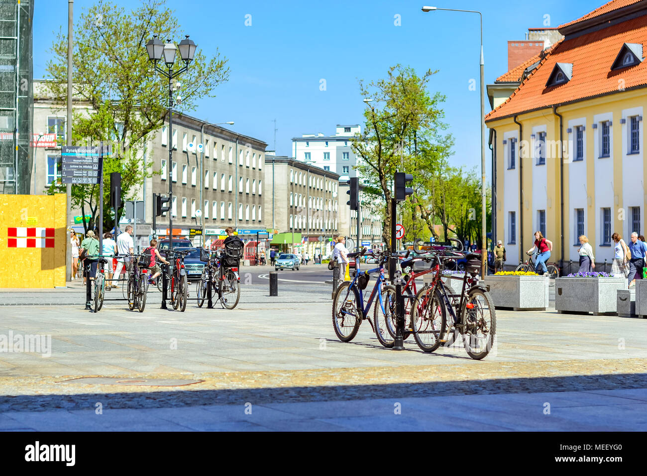 Bialystok, Pologne - 30 Avril 2012 : Le vélo est garé sur le stationnement des vélos sur le trottoir. Les touristes à pied dans la journée ensoleillée sur la place centrale de pavés Banque D'Images