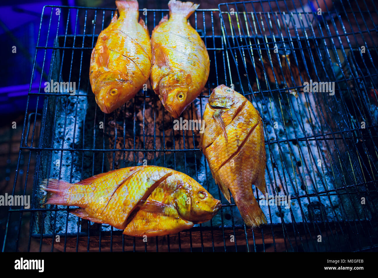 Le poisson grillé est utilisé sur le grill au charbon, un aliment populaire au marché du soir au Vietnam Banque D'Images