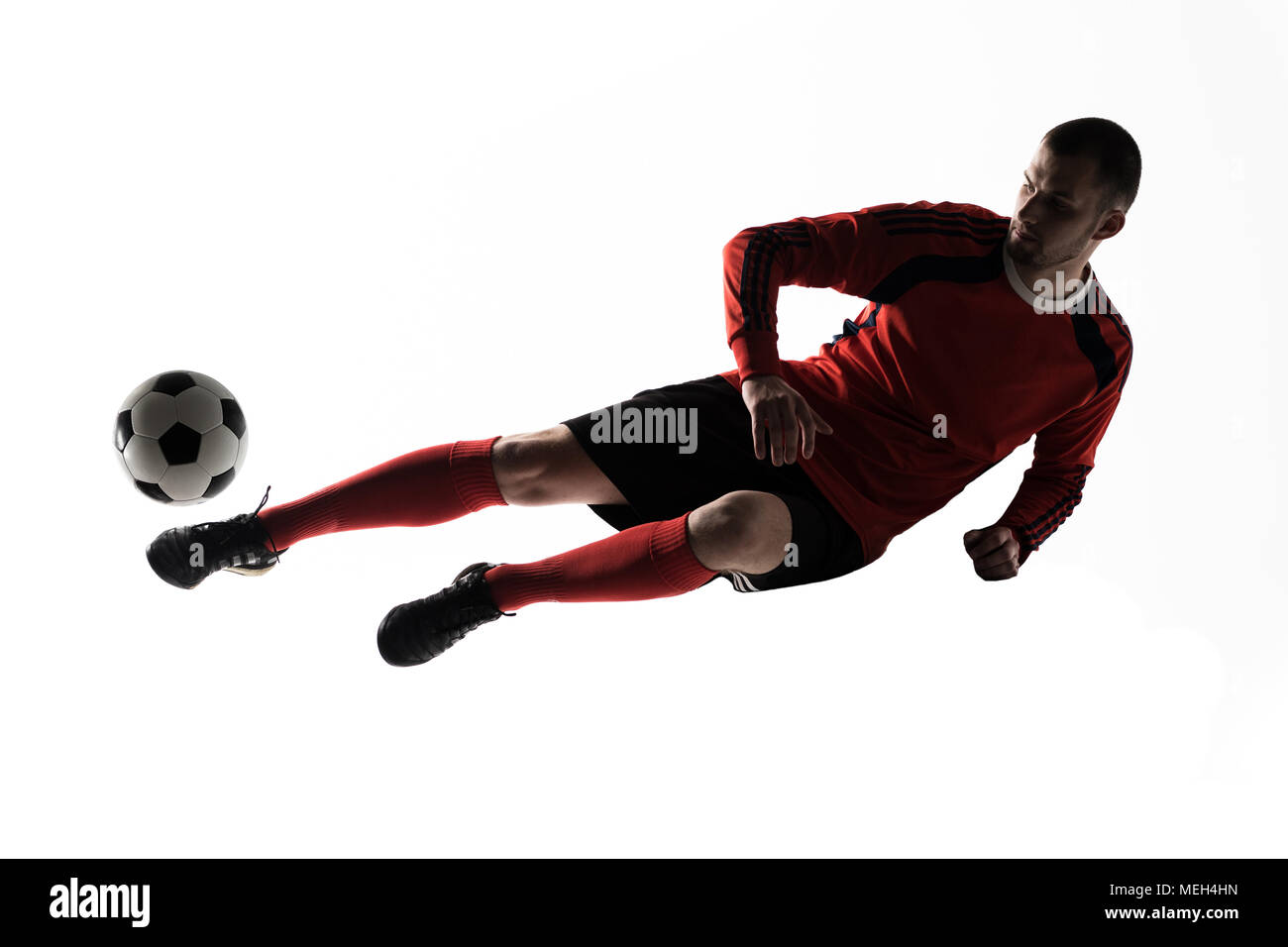 Un joueur de soccer de race blanche homme jouant des coups en silhouette isolé sur fond blanc Banque D'Images