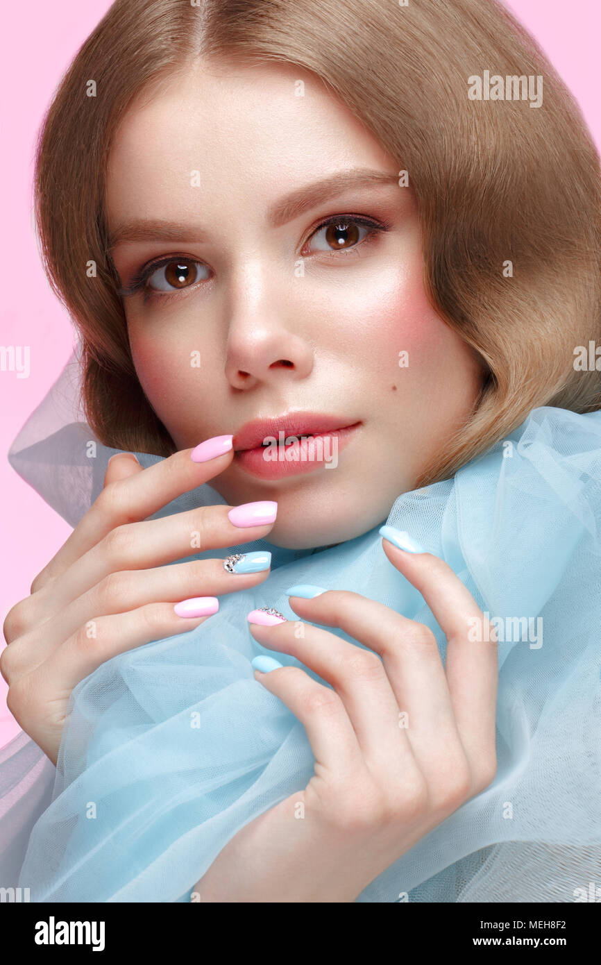 Belle fille avec la lumière douce et de maquillage manucure en bleu vêtements. Beauté Visage. Ongles Design. Banque D'Images