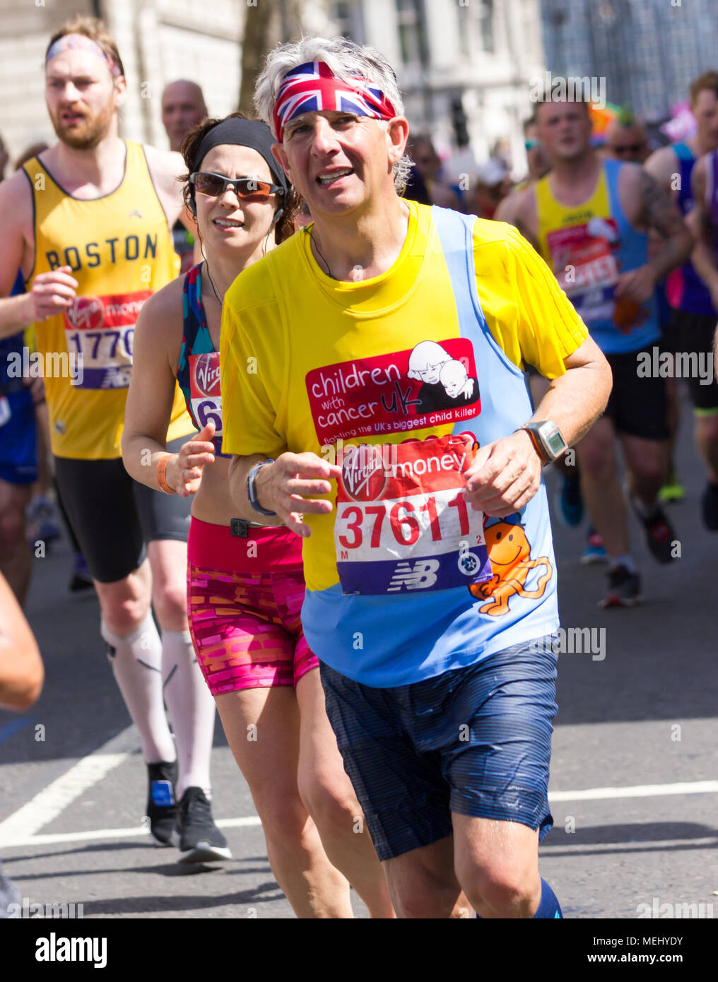 St James's Park, The Birdcage Walk, London,UK. 22 avril, 2018. L'élite et des milliers de plaisir porteur se diriger vers le palais de Buckingham en brillant soleil du printemps lorsqu'ils entrent dans le dernier mile de la Vierge 2018 Marathon de Londres. Plusieurs des participants ont été touchés par l'un des marathons les plus chauds jours de l'enregistrement et a besoin de l'aide d'autres coureurs à terminer le dernier km en approchant du Mall, tandis que d'autres ont été traités par les équipes de premiers secours. Malheureusement, d'un coureur Matt Campbell, 29 ans, s'est effondrée après 22,5 kilomètres et est mort plus tard à l'hôpital . Credit : Alan Fraser Banque D'Images