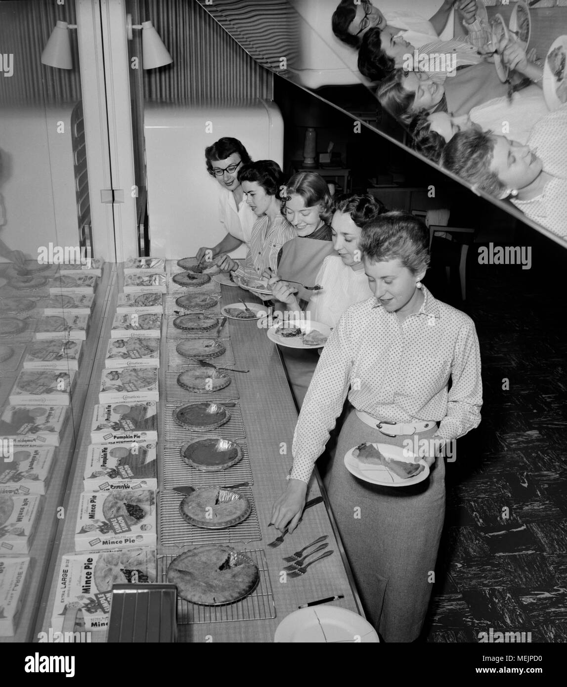 Cinq jeunes femmes sont sur le point de goûter quelques saveurs assorties de Simple Simon Pies, ca. 1957. Banque D'Images