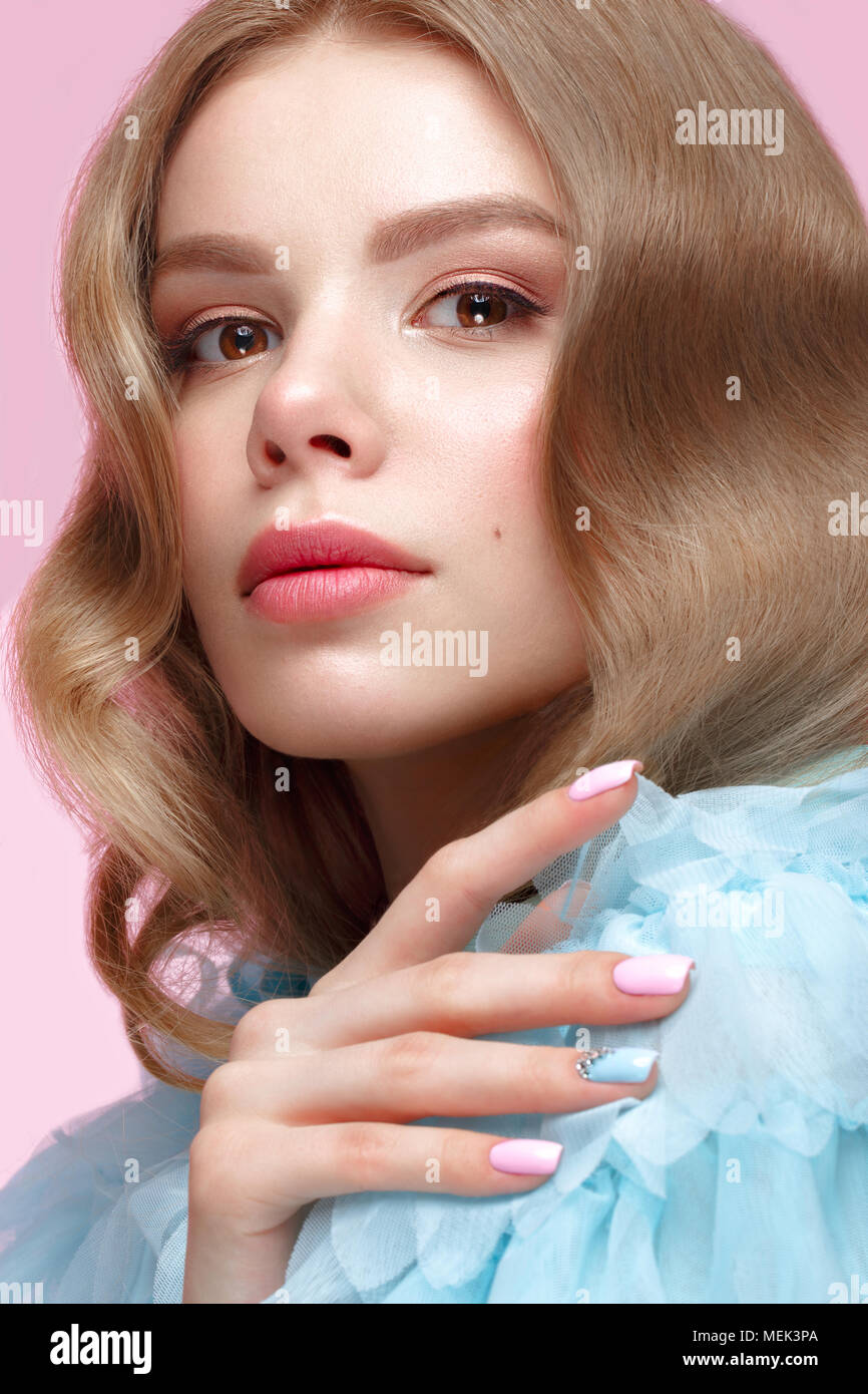 Belle fille avec la lumière douce et de maquillage manucure en bleu vêtements. Beauté Visage. Ongles Design. Banque D'Images