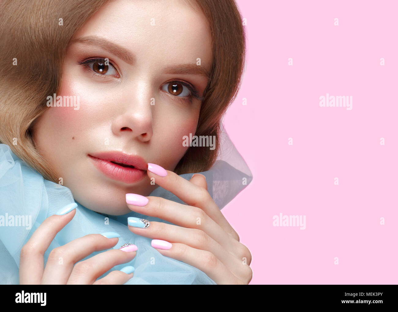 Belle fille avec la lumière douce et de maquillage manucure en bleu vêtements. Beauté Visage. Ongles Design. Banque D'Images