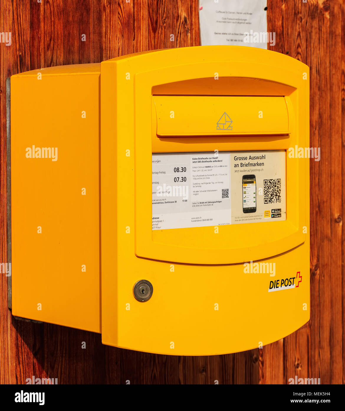 Filisur, Suisse - 3 mars, 2017 : une boîte jaune de La Poste Suisse sur un mur en bois, l'accent principal sur l'avant de la boîte. La Poste Suisse est le national Banque D'Images
