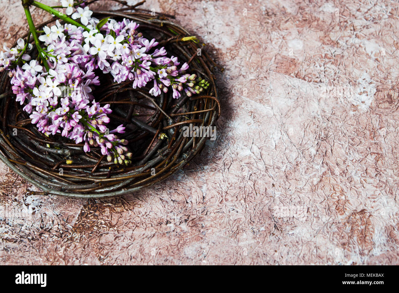 Bouquet de fleurs lilas colorés dans un bol en osier Banque D'Images