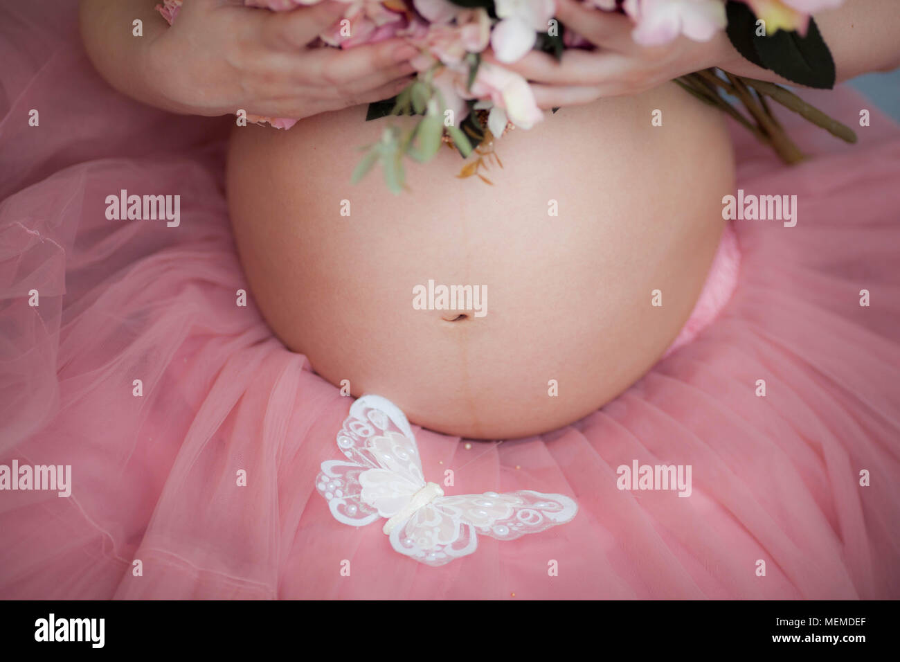 Jeune femme enceinte détient les mains sur son ventre. Concept d'amour. Banque D'Images