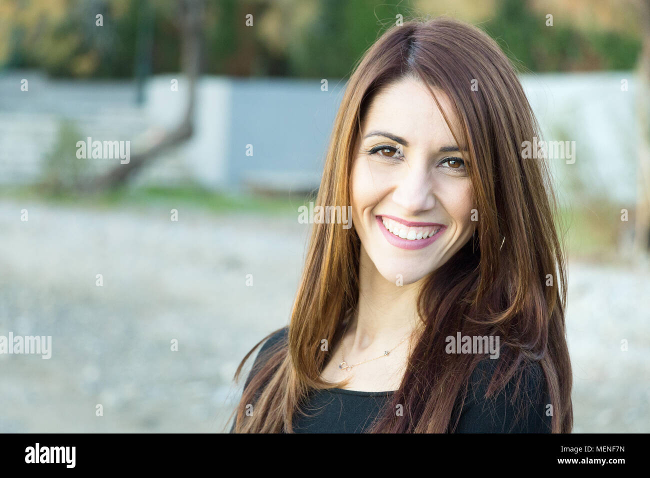 Portrait d'une femme à la caméra avec le sourire à pleines dents, joyeux, à l'extérieur. Banque D'Images