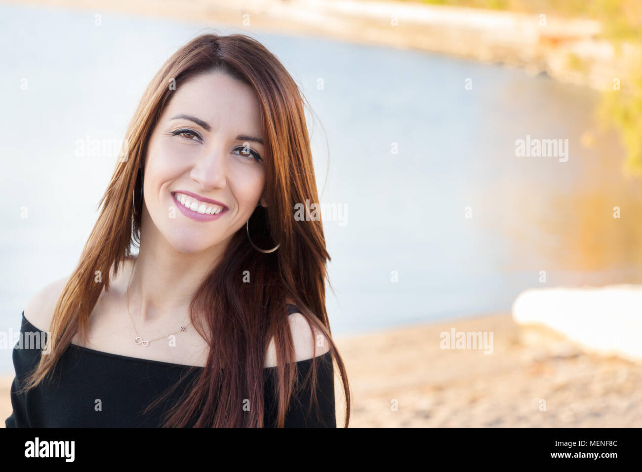 Portrait of a woman looking at camera, souriant, joyeux, à l'extérieur. Banque D'Images