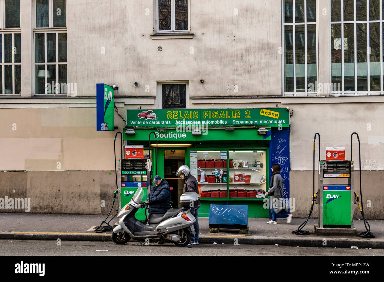 Un opérateur de pompe à essence ravitaille un scooter à une station service sur le Boulevard de Clichy, Pigalle, Montmartre, Paris Banque D'Images