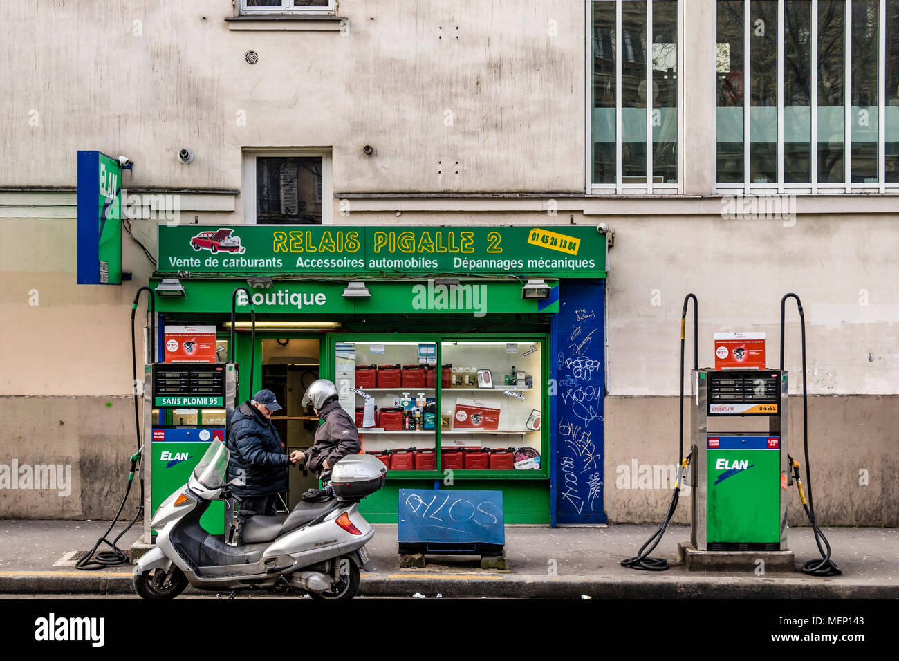 Un opérateur de pompe à essence ravitaille un scooter à une station service  sur le Boulevard de Clichy, Pigalle, Montmartre, Paris Photo Stock - Alamy