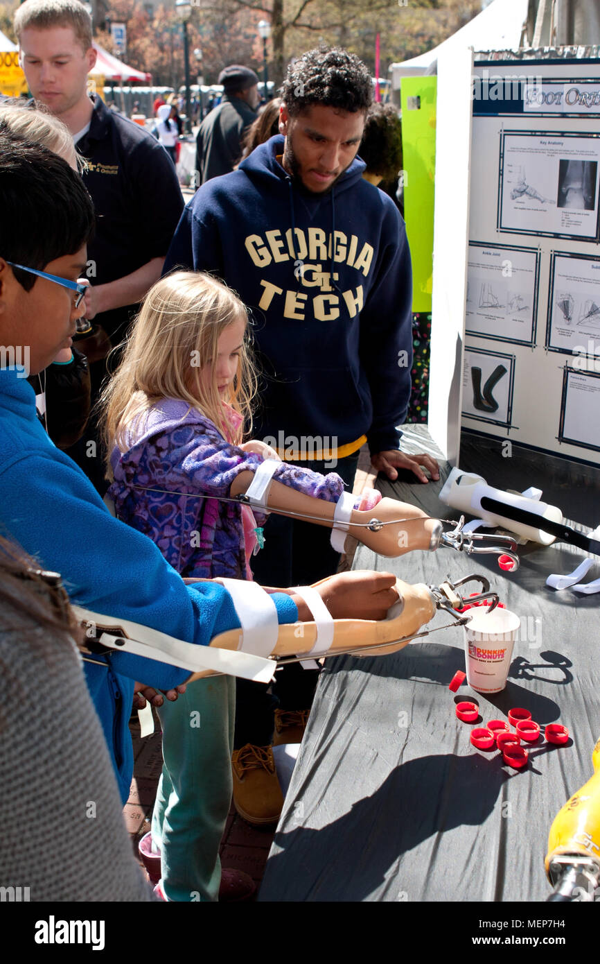 Enfants tentent d'abandonner des capsules de bouteille dans une tasse à l'aide d'un bras prothétique et de crochets, à l'Atlanta Science Fair le 28 mars 2015 à Atlanta, GA. Banque D'Images