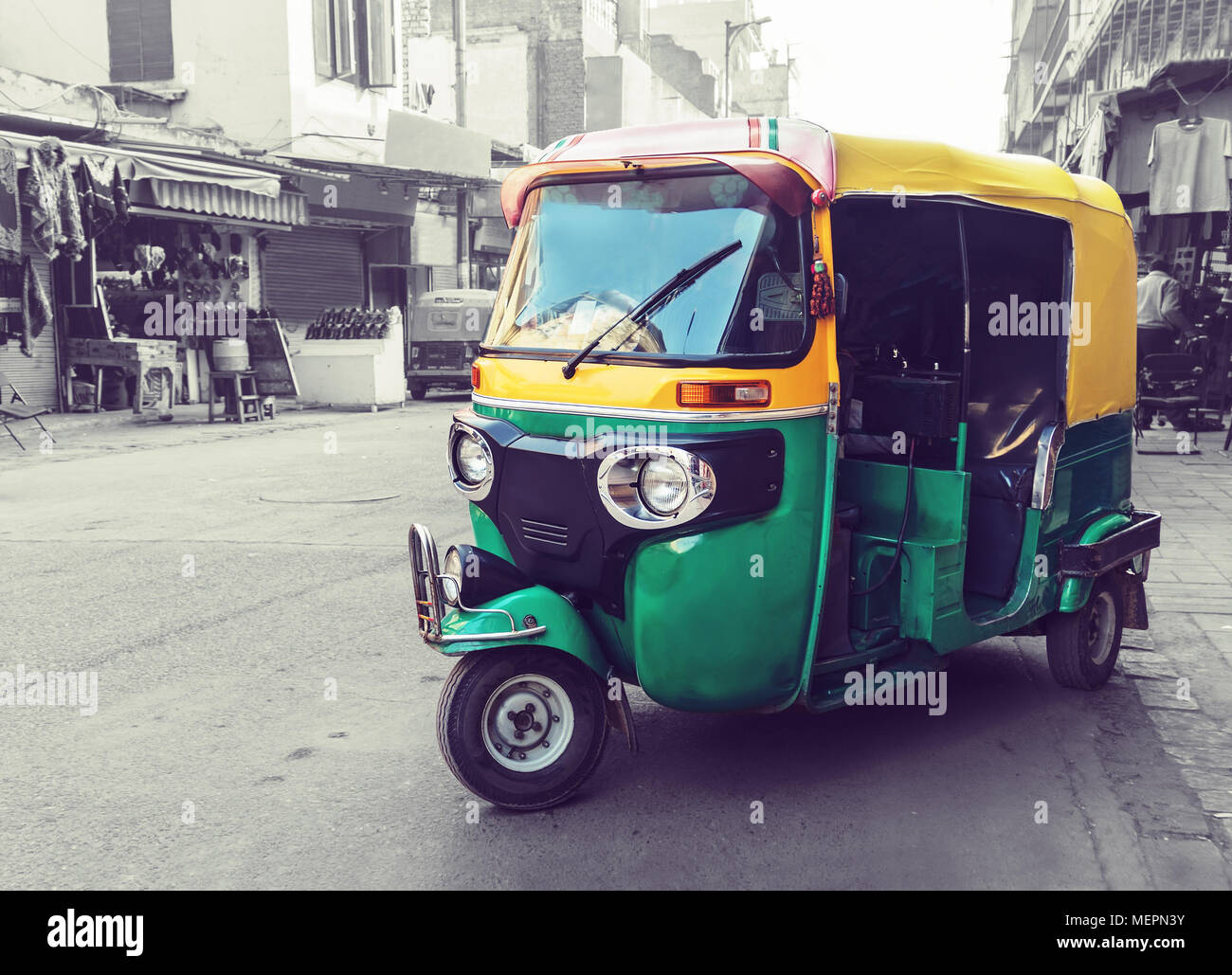 Jaune Vert traditionnel tuk tuk taxi sur la rue. Transports publics indiens dans les rues de New Delhi. Banque D'Images