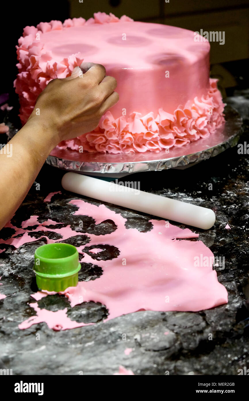 Decorer Un Gateau Glacage Rose Petales De Fleurs Sont En Place Sur L Accueil Fait Par Gateau Glacage Rose Et De Main De Femme Asiatique En Face Du Gateau Est Un Roliin Blanc